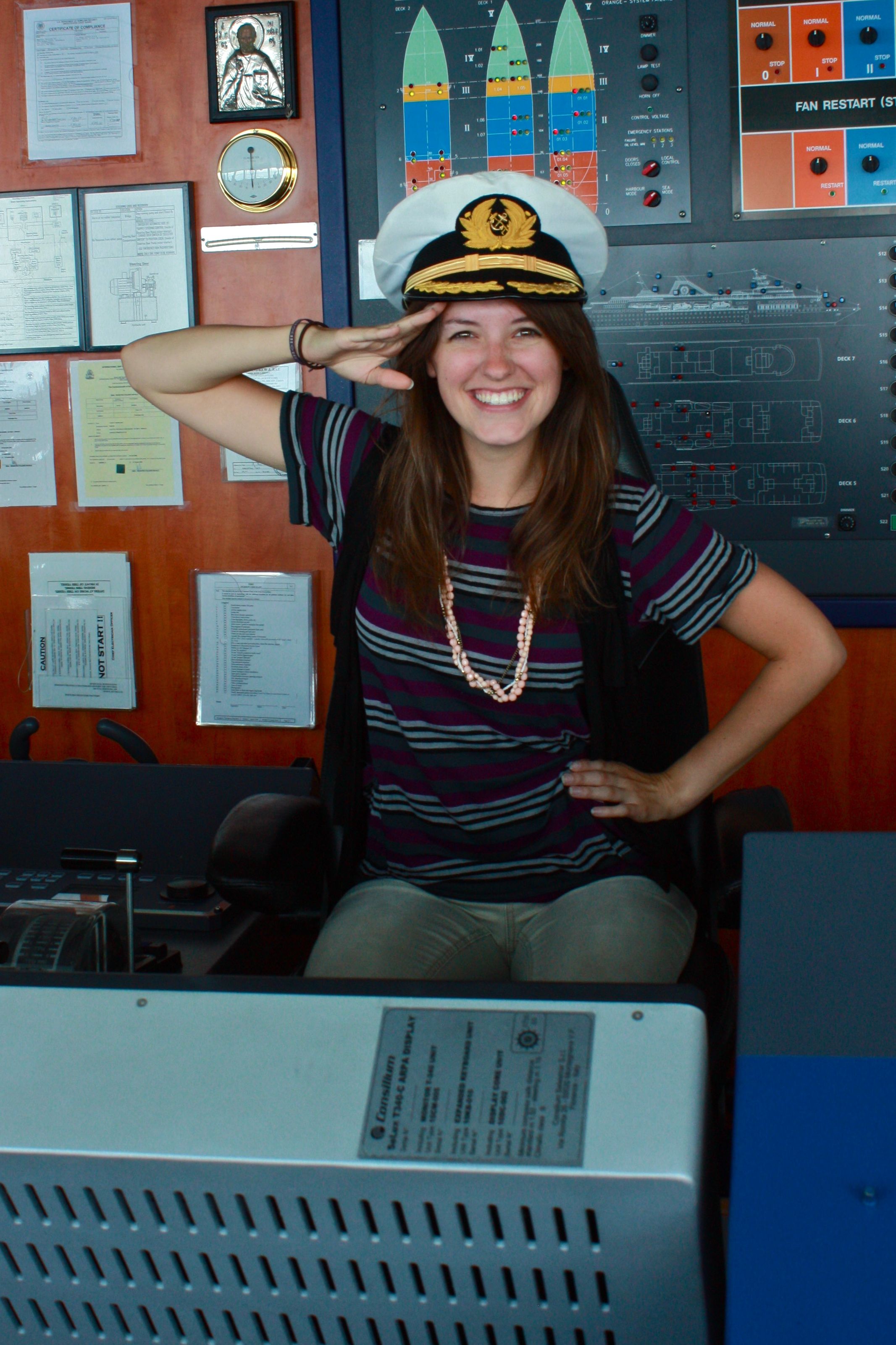 Young Women Saluting in Cruise Ship Bridge with Captain Hat